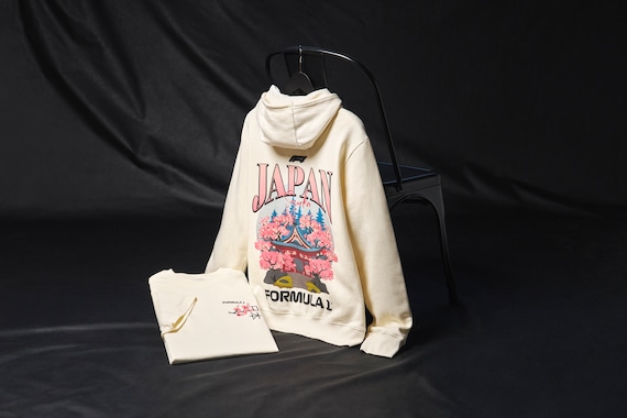Con la Fórmula 1 rumbo a Japón para el Gran Premio de Japón de 2025, prepárate para el evento principal con esta prenda oficial que celebra la cultura y el diseño japoneses. Una rama de sakura luce en el pecho con escritura en inglés y japonés, mientras que la espalda luce la ilustración de un templo sintoísta tradicional y el texto Suzuka, sede de lo que sin duda será una memorable tercera ronda de la temporada 2025 de F1.